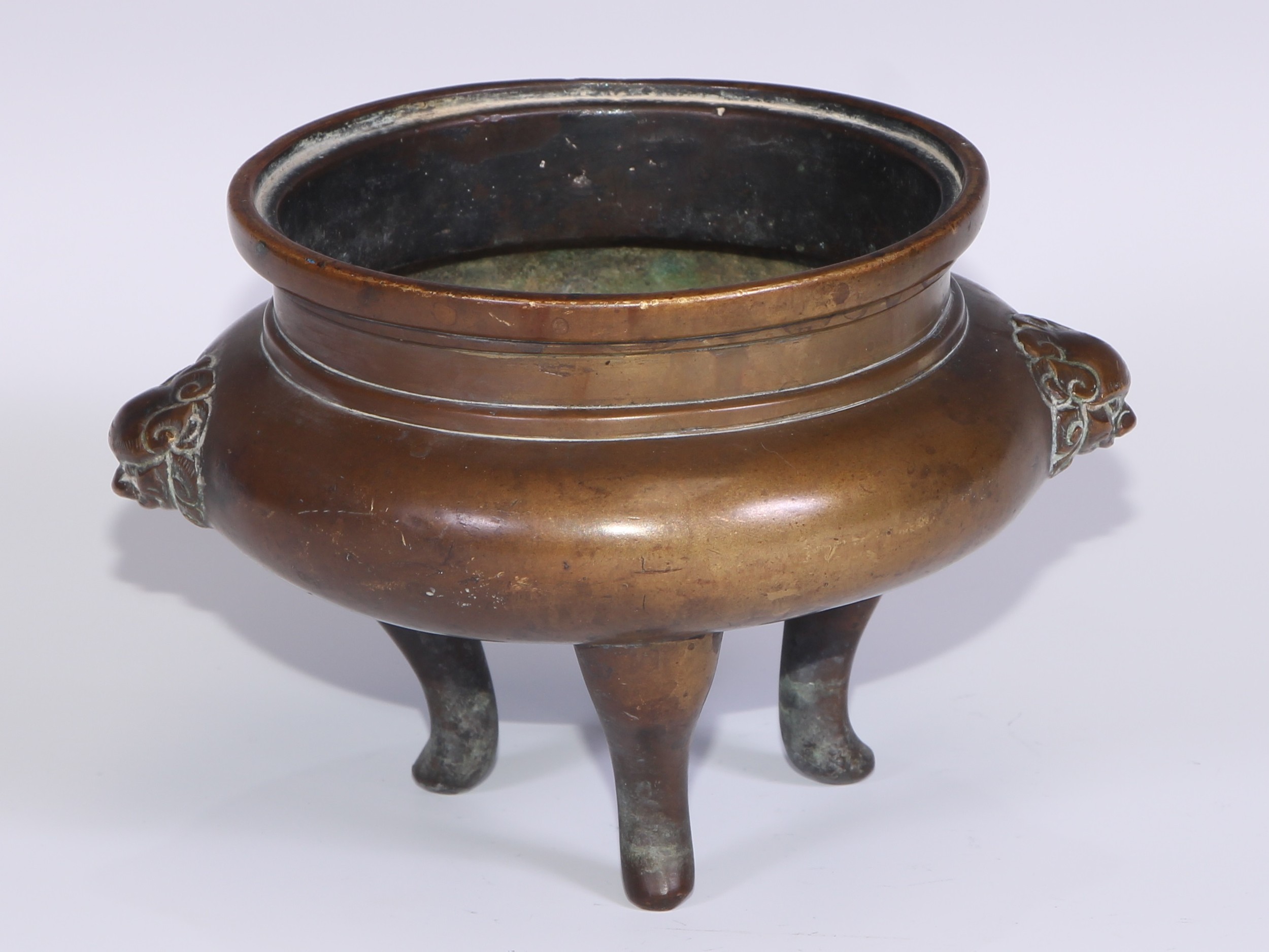 A Chinese bronze tripod censer, cast temple lion mask handles, tall serpentine legs, 16cm wide, 19th