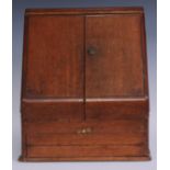A Victorian oak table top slope-front combination writing and stationery cabinet, the hinged twin-