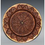 A Tibetan copper circular charger, chased with stylised lotus and set with jade and agate cabochons,