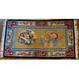 A Chinese rug decorated with a ferocious dragon and fenghuang, on a golden ground, 183 x 95cm.
