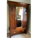 An early 20th Art Nouveau wardrobe, moulded cornice, bevelled mirror door, flanked by carved leafy