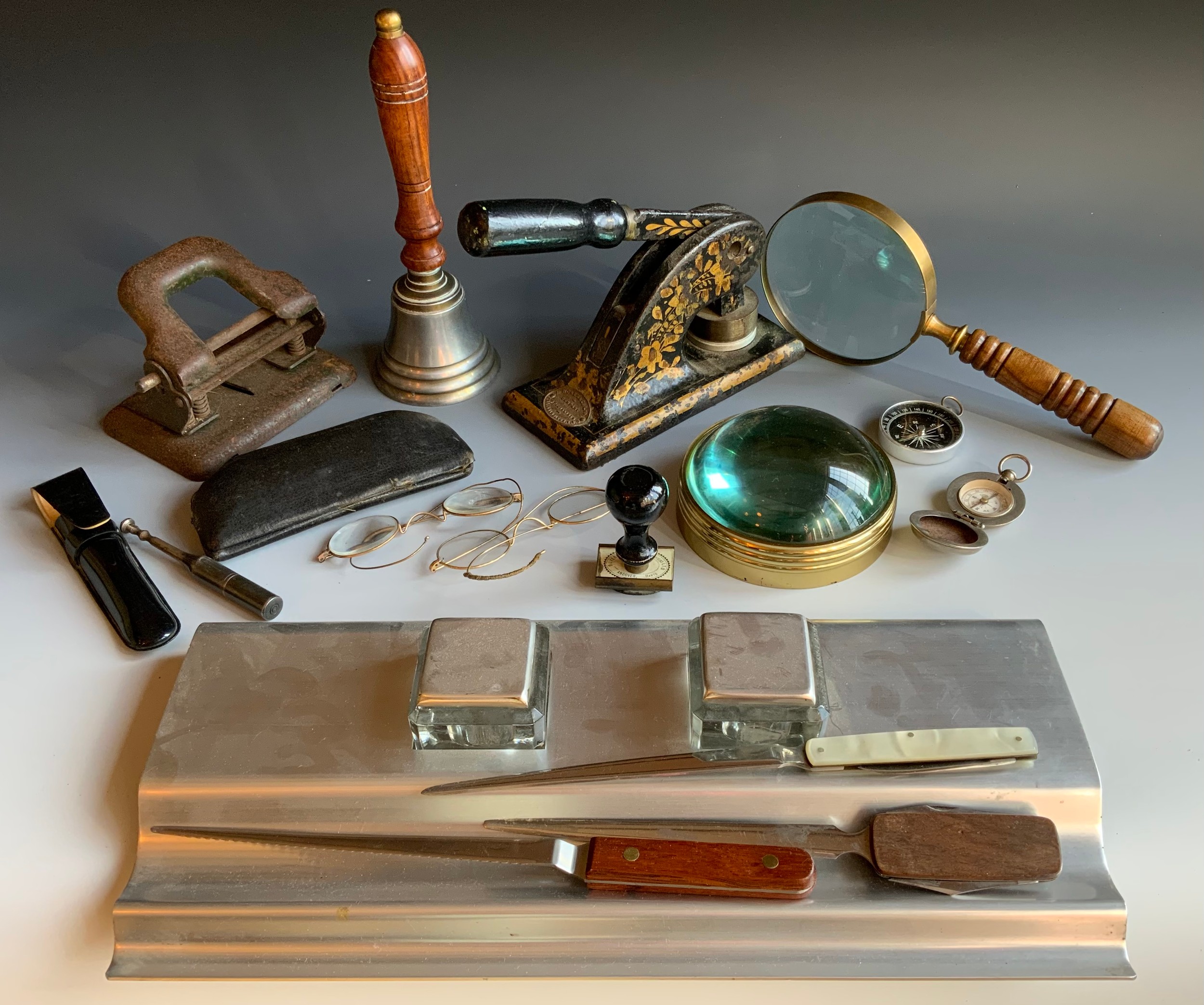 A desk school bell; a magnifying glass; compasses; wire glasses; contemporary desk stand; etc **