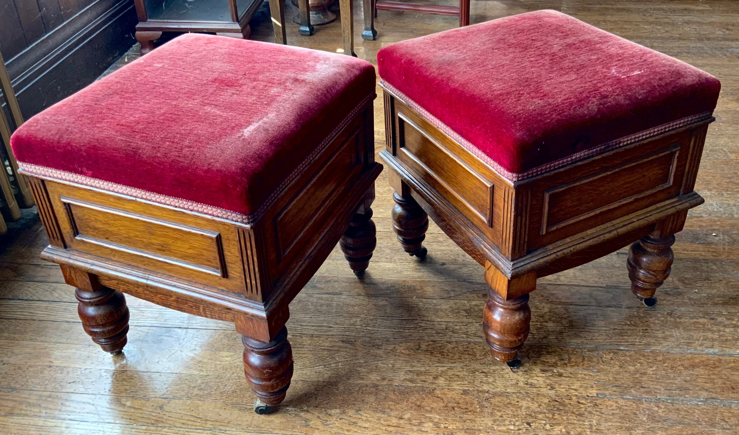A pair of Victorian oak stools, hinged stuffed over seats, panelled sides, turned legs, on