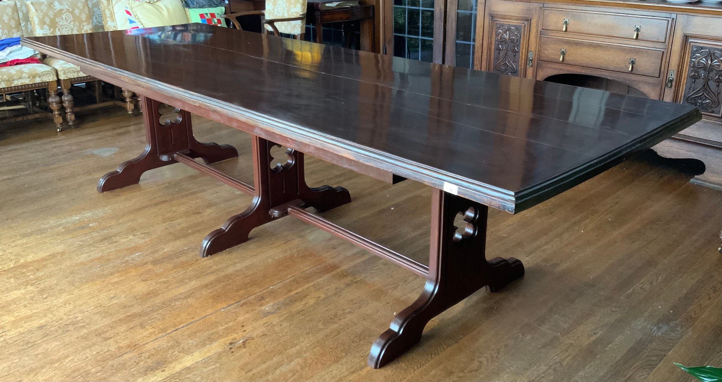 A large rectangular mahogany stained dining table, moulded edge, central stretcher with three fluted