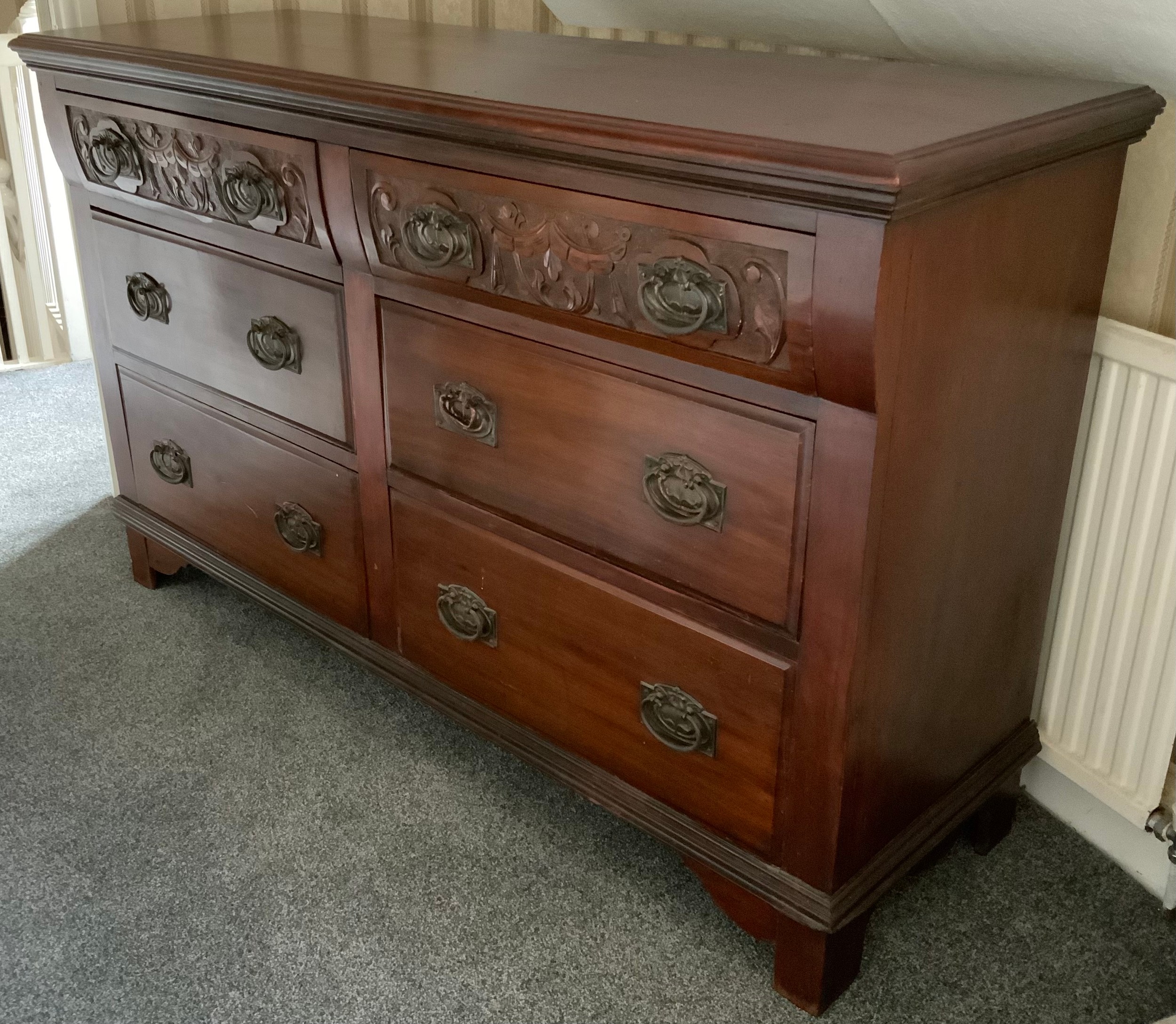 An early 20th century mahogany sidebaord, with six drawers, carved with swags, Art Nouveau