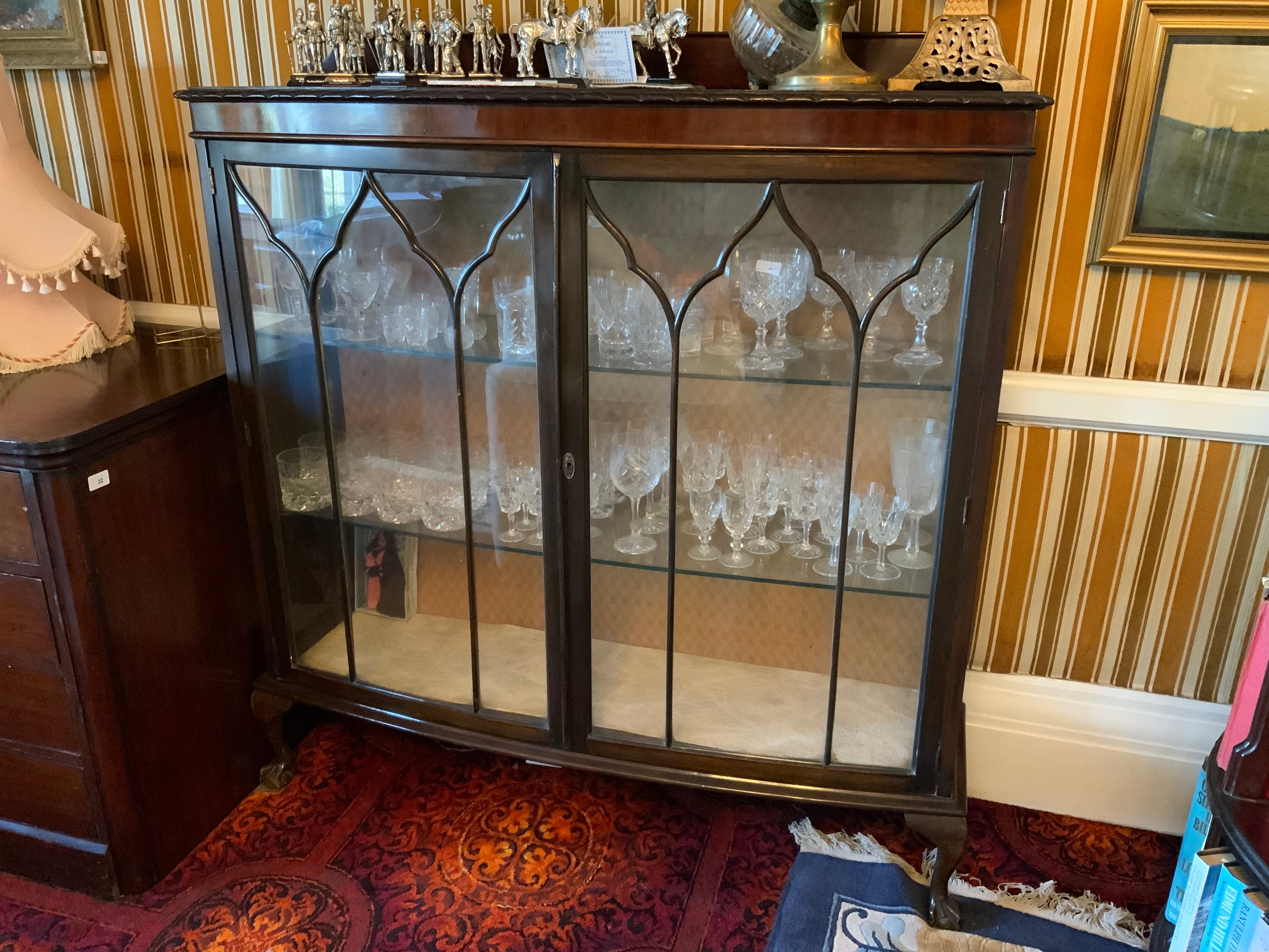 An early 20th century mahogany bow front double door display cabinet, ball and claw feet, 134cm