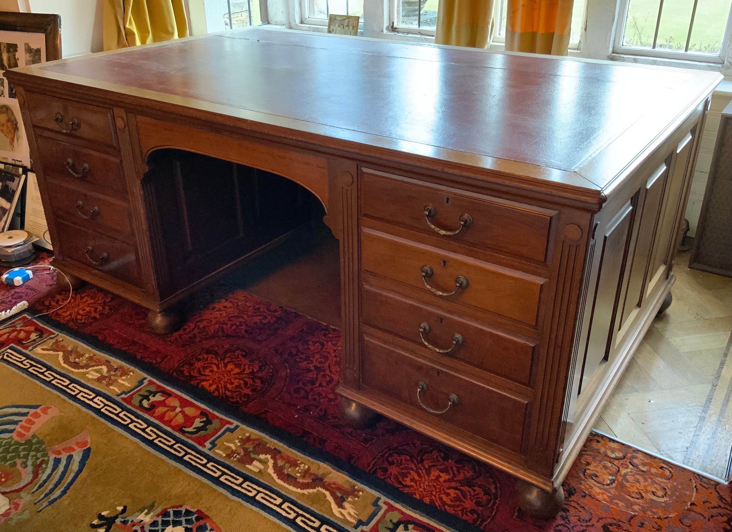 A late 19th/early 20th century mahogany partners desk, tooled leather writing surface, central