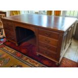 A late 19th/early 20th century mahogany partners desk, tooled leather writing surface, central