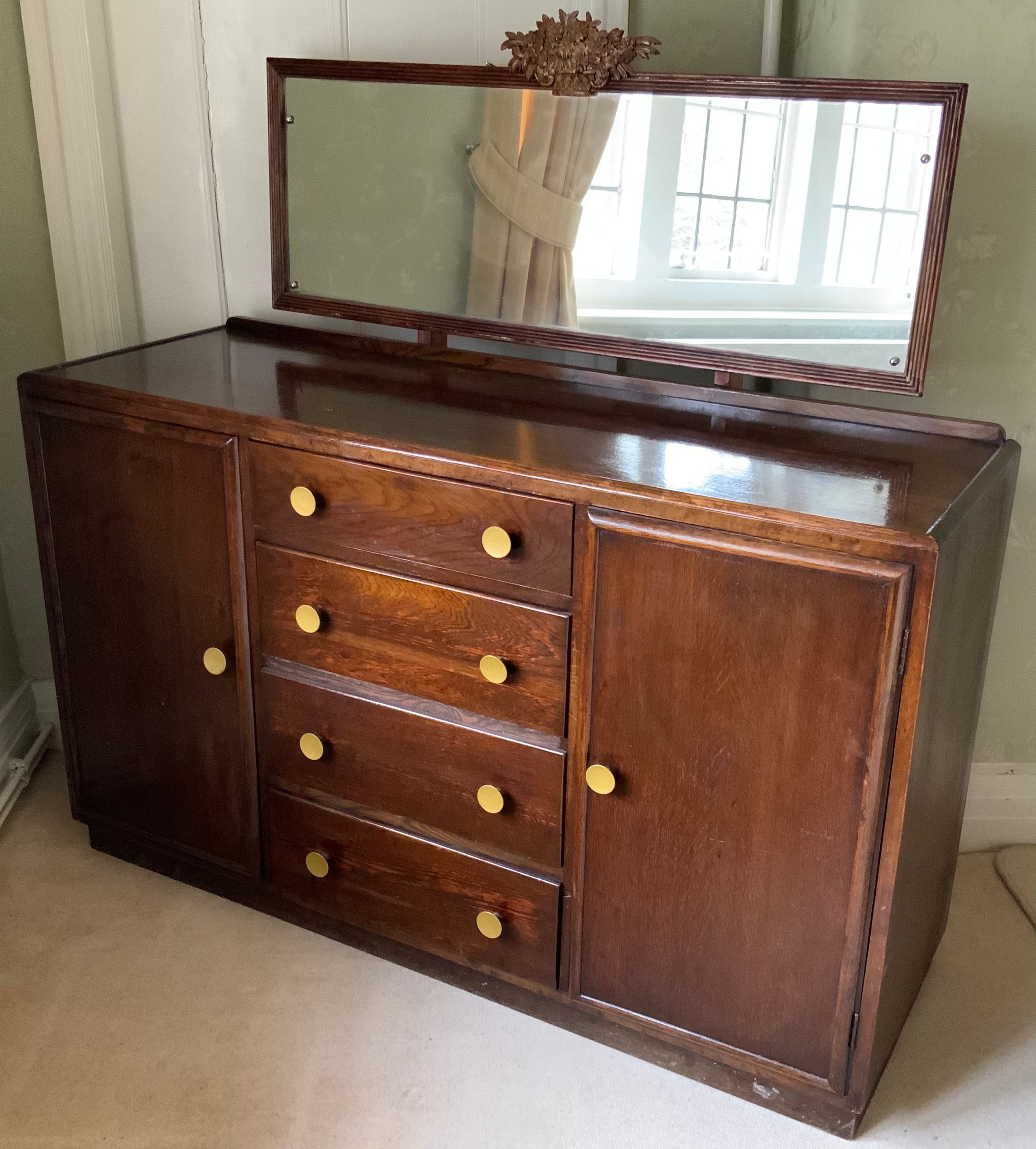 An oak sideboard, with four drawers flanked by cupboard doors, now converted to a dressing chest,