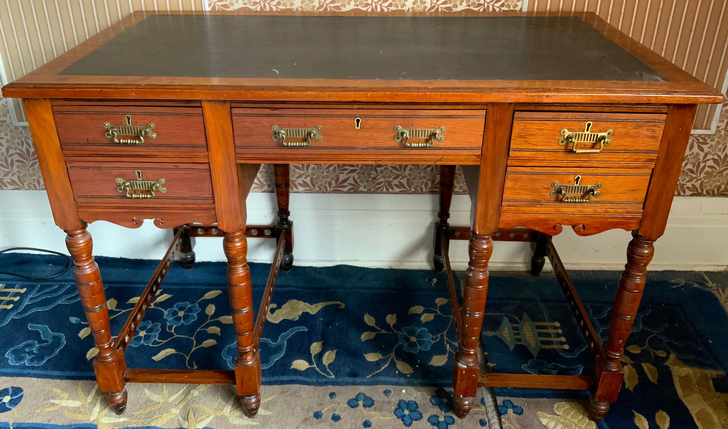 A Victorian mahogany writing desk, with inset writing surface above an arrangement of five