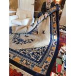 A large Chinese woollen carpet, decorated with butterflies and moths, stylised blossoms and