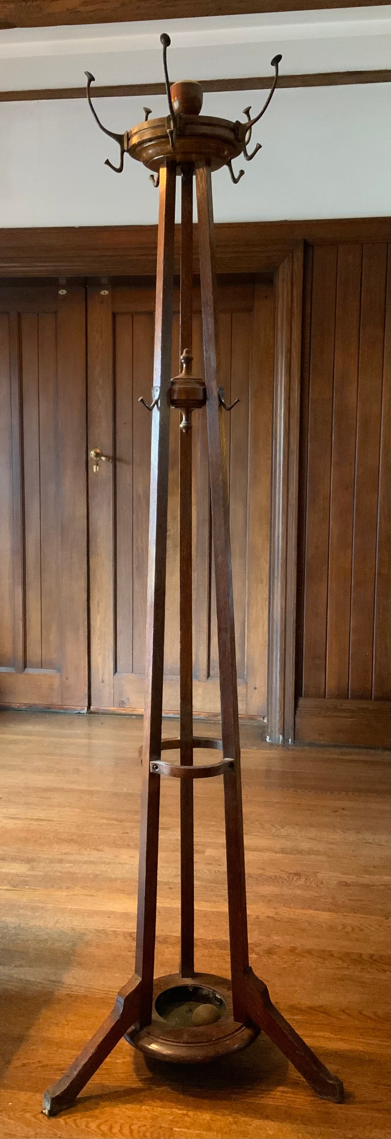 An early 20th century oak coat, hat and umbrella stand, turned finials, three splayed legs ** We