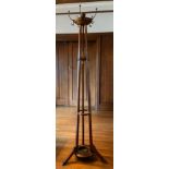 An early 20th century oak coat, hat and umbrella stand, turned finials, three splayed legs ** We