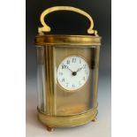 A French brass oval carriage clock, Roman numerals, swing handle, 11cm high ** We would please ask