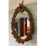 A mid 20th century gilt and plaster Rococo wall mirror, 64cm high, 46cm wide ** We would please