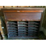 A late 19th century mahogany tambour front cabinet, egg-and-dart frieze, the interior with three