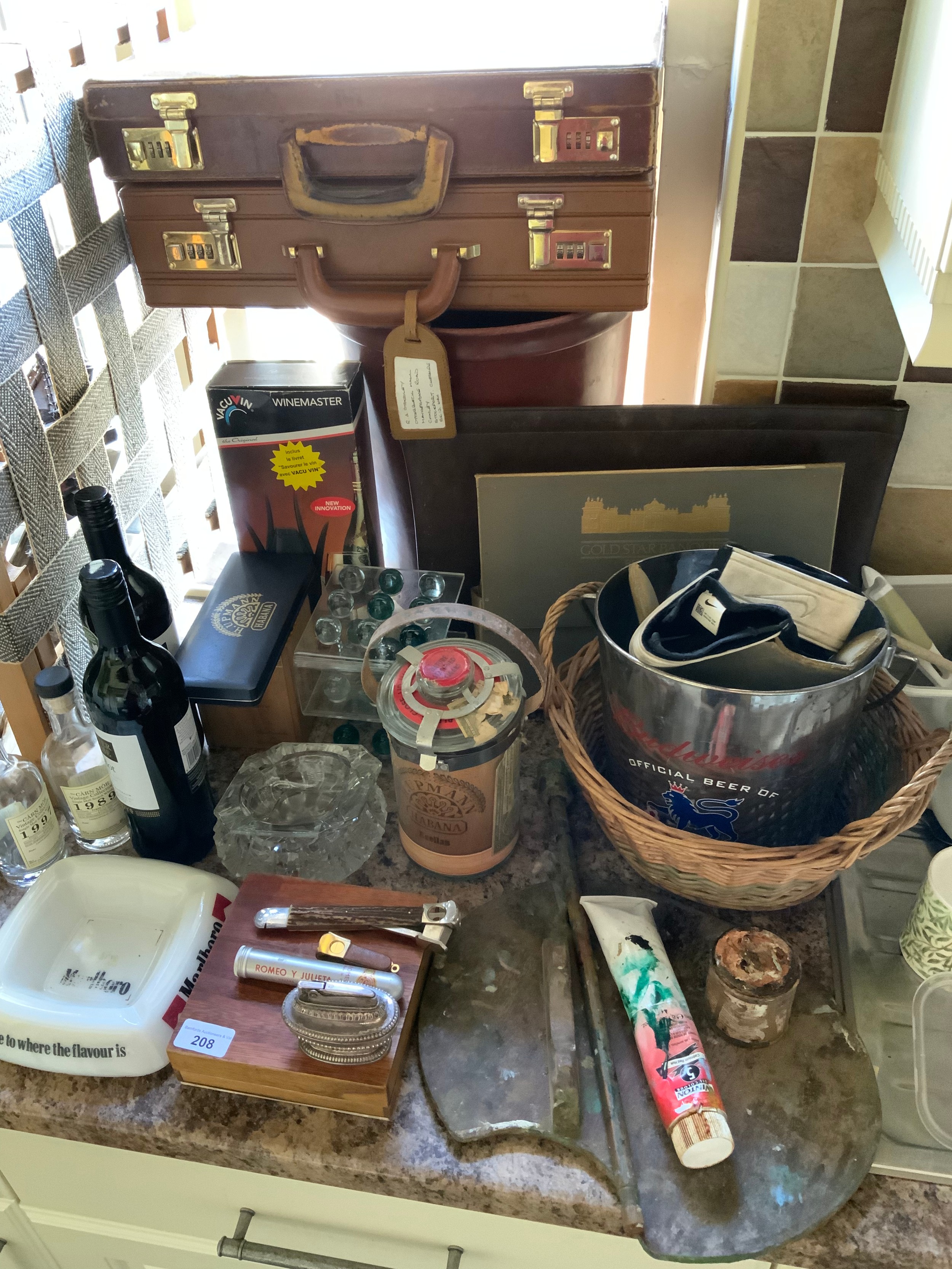 An Artist's easel; briefcases; wine master; cigars; Chapter & Verse Merlot; Budweiser ice bucket;