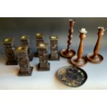 A set of six carved ebonised table candlesticks, 19cm high; a pair of oak candlesticks, c.1930;