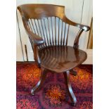 An early 20th century mahogany office swivel chair, spindle back, shaped seat, four splayed legs,