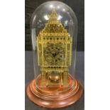 A brass skeleton clock as Westminster Elizabeth Tower, glass dome, 29cm high