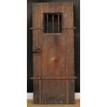 A museum replica of a medieval jail or cell door, 180cm high, 73.5cm wide, 9cm deep