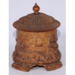 A Black Forest cylindrical novelty box and cover, carved as a thatched cottage or lodge, 16cm