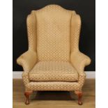 A George II Revival wingback armchair, 119.5cm high, 94cm wide, the seat 55cm wide and 53cm deep