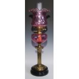 A Victorian brass Corinthian column oil lamp, cranberry glass shaped and reservoir, 62cm high, c.