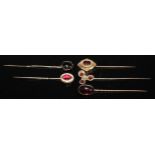 A 19th century oval cabochon garnet stick pin, yellow metal mount; another smaller; others enamelled