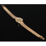 A ladies 9ct gold Omega wristwatch, the 2cm circular champagne dial with baton markers, mesh link