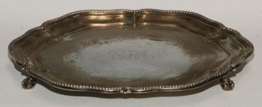 A George V silver shaped circular salver, fluted beaded border, ball and claw feet, 32cm diam,
