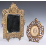 A William Tonks and Sons brass rectangular mirror, cast with radiating mask, cherubs and pierced
