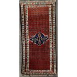 A Persian Malayer woollen rug, with central motif surrounded rows of motifs, -geometrical borders,