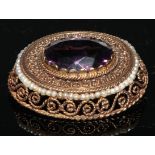A Victorian style amethyst and gold coloured metal oval brooch, the central faceted within open