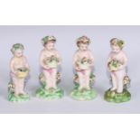 A harlequin set of four Derby patch mark figures, of putti, each modelled with a flowering basket,