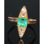 An emerald and diamond elongated navette shaped ring, central square cushion cut emerald flanked