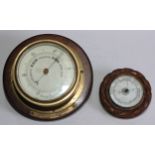 A mid 20th century brass aneroid wall barometer, mounted on oak, 25cm diameter; another aneroid wall