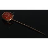 A 19th century carnelian stick pin, oval intaglio portrait as a warrior profile, to sinister,