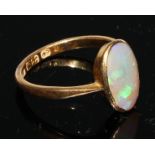 A 22ct gold and opal ring, the oval cabochon stone bezel set, plain shank, size M/N, 3.1g gross