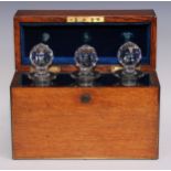 A late Victorian brass bound oak three-section decanter box, hinged cover enclosing three canted