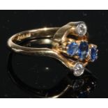 A sapphire and diamond twist ring, three graduated round cut pale blue sapphires, estimated sapphire