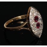 A diamond and ruby navette shaped 18ct gold ring, the two central facet cut rubies within a field of