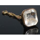 A yellow metal fob seal, set with a shaped rectangular intaglio rock crystal, engraved with a