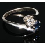 A two stone diamond and sapphire cross over ring, 18ct white gold shank, size M/N