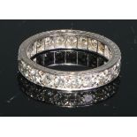 A diamond and white metal eternity ring, a continuous band of brilliant cut stones, engraved with