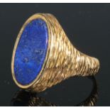 A large 18ct gold seal ring, the shoulders and shank textured, oval lapis lazuli panel, size S,