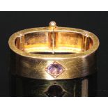 A 15ct gold oval scarf clip, quite plain, centered with a single amethyst, 3cm wide, 6.1g gross