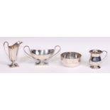 A George VI silver helmet shaped cream jug and pedestal sugar basin, of George III design, the