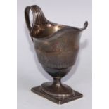 A George III silver helmet shaped pedestal cream jug, bright-cut engraved and outlined with