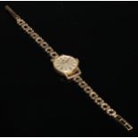 A ladies 9ct gold Tissot wristwatch, the 1.8cm champagne dial with baton markers, 13.g gross